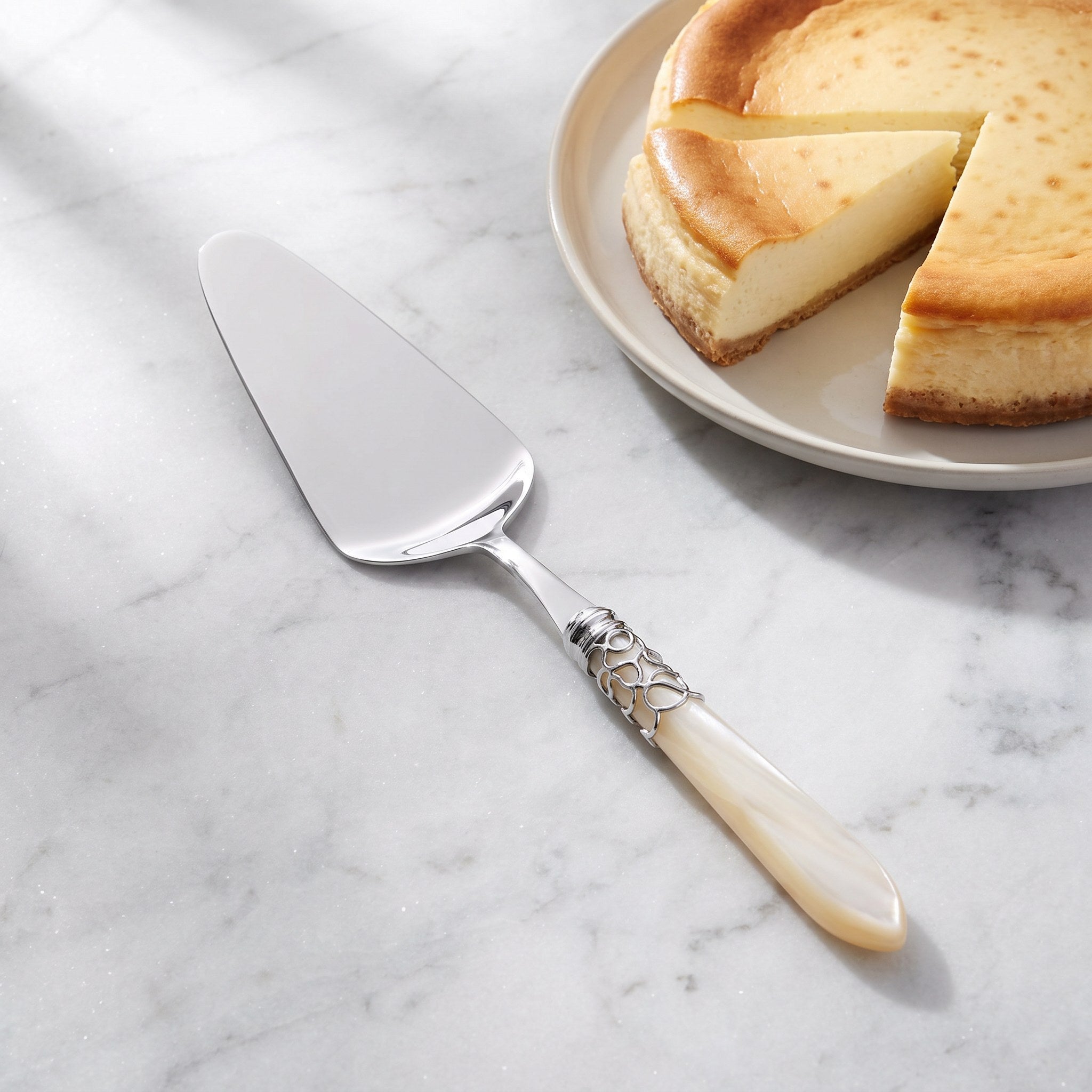 Rounded cake server with a baked cheesecake on grey marble