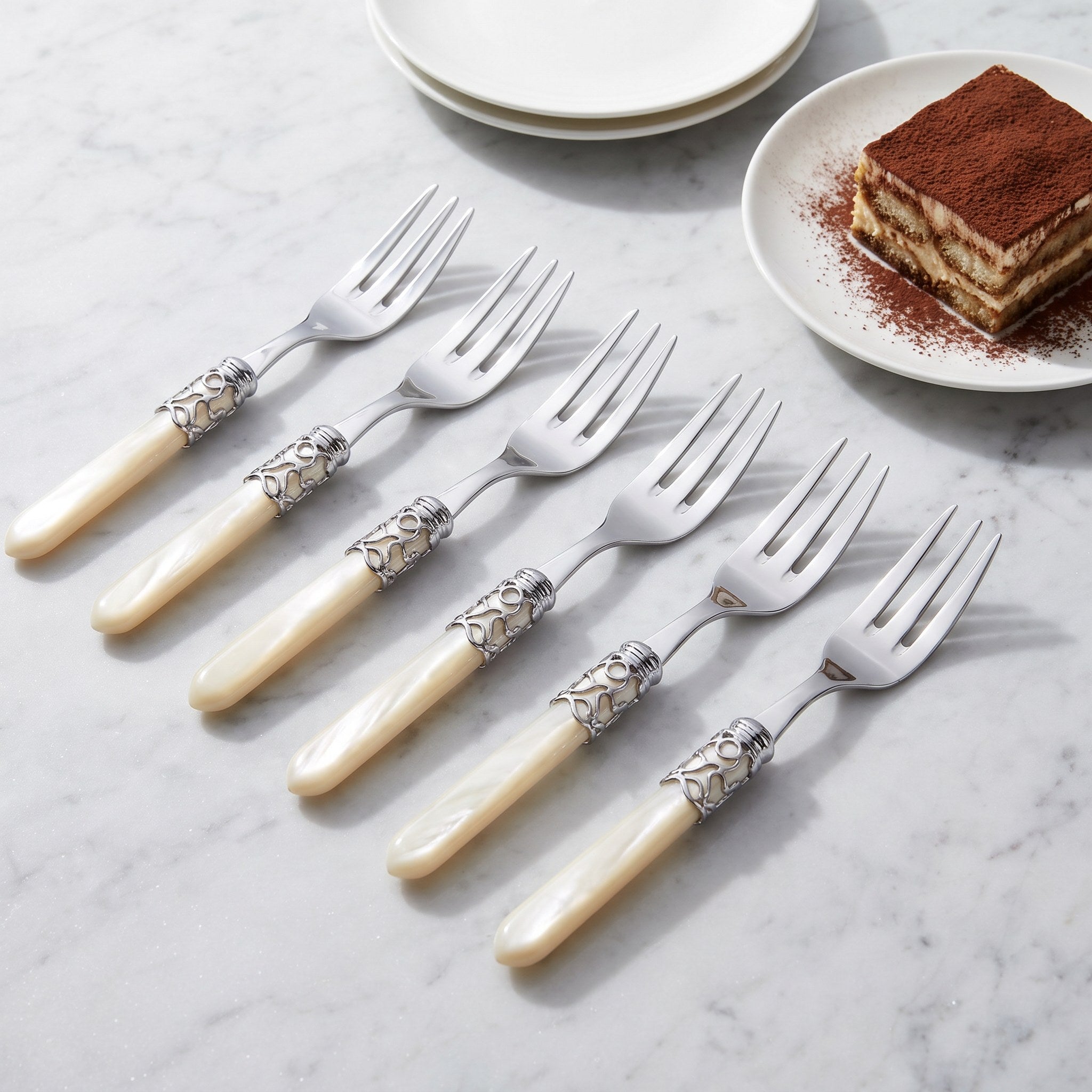 Six three-tine cake forks with tiramisu on grey marble