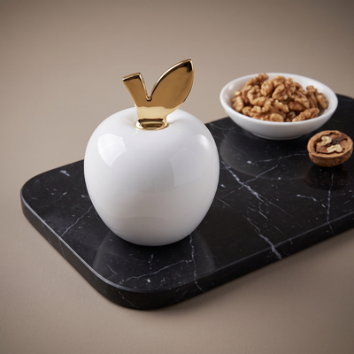 Casa Bugatti Eden white apple nut cracker with gold leaf on black marble, walnuts
