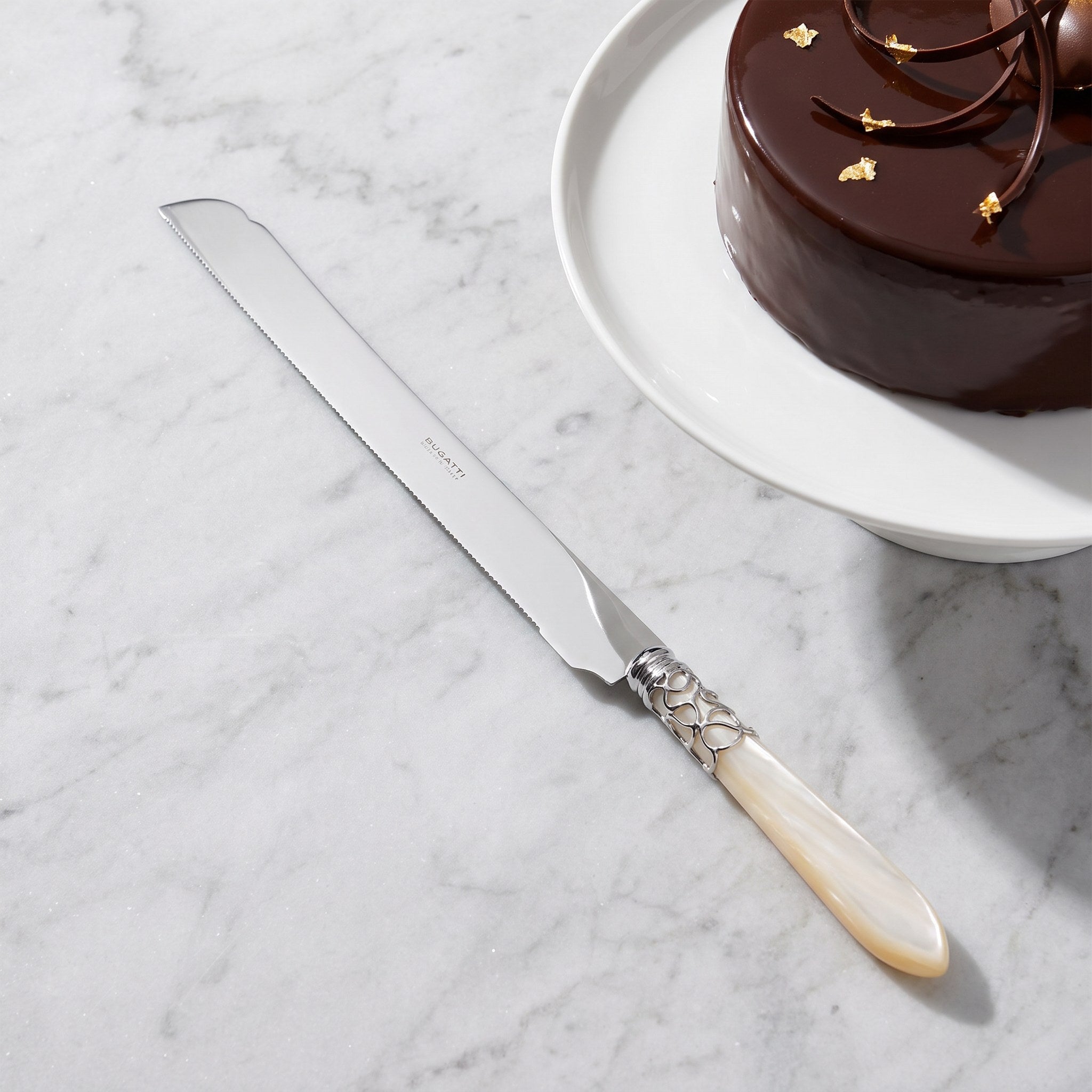 Long cake knife 32 cm with a chocolate mirror-glaze torte on grey marble