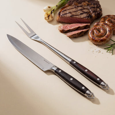 Casa Bugatti BBQ carving knife and two-prong fork, satin steel with dark wood handles, with grilled steak and sausages