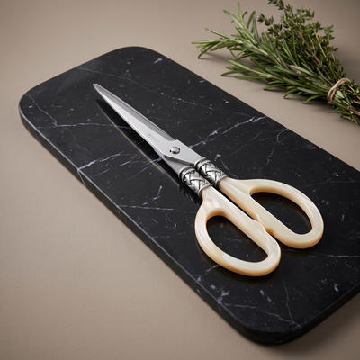 Casa Bugatti kitchen shears with pearlescent ivory handles on a black Marquina marble board