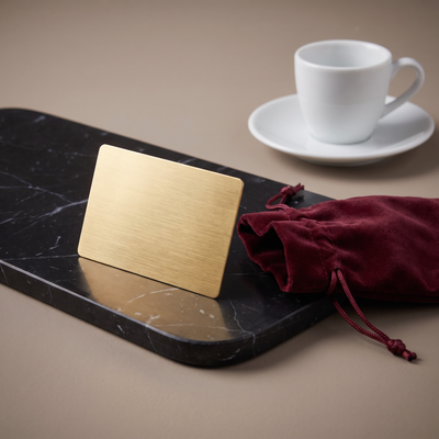 Casa Bugatti gift card in brushed gold with burgundy velvet pouch on black marble