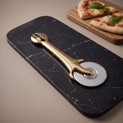 Casa Bugatti KISS gold pizza cutter on black marble with pizza margherita