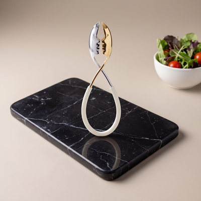 Casa Bugatti Kiss tongs, gold and chrome kissing faces, on black marble