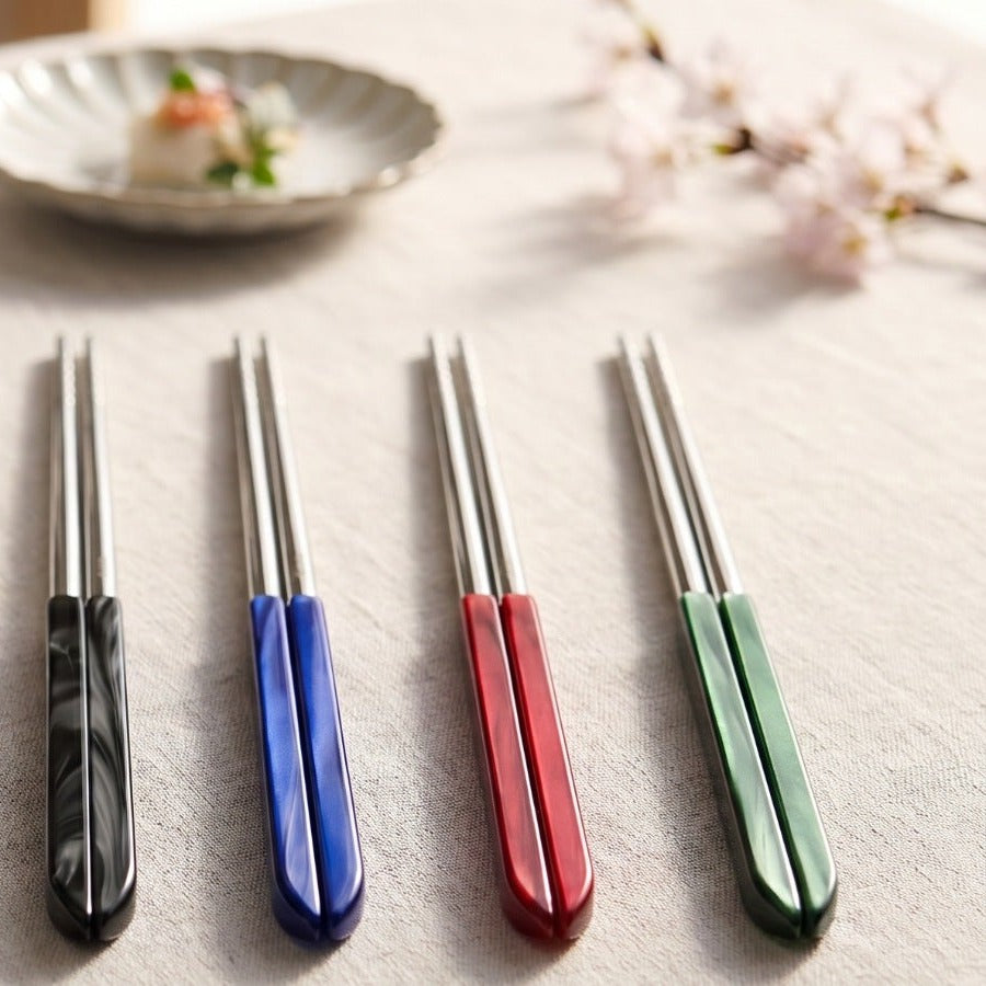 Casa Bugatti chopsticks in black, blue, red and green on linen with a sashimi plate and cherry blossom